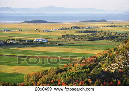 Stock Photo - Artist's Choice: View Of Mountains, Farm, Fields And St. Lawrence River At Sunset, Bas-Saint-Laurent Region, Saint-Pascal, Quebec. Fotosearch