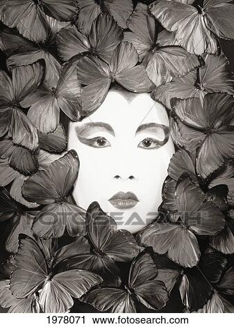 Stock Image - Asian Woman, Painted White Face Surrounded By Butterflies (Sepia Photograph).. Fotosearch