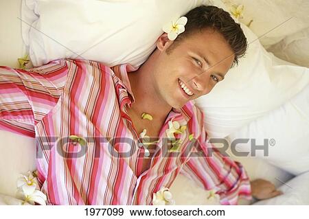 Attractive Man Laying In Bed Covered In Plumerias. View Large Photo Image Stock Photo - Attractive Man Laying In Bed Covered In Plumerias.. Fotosearch