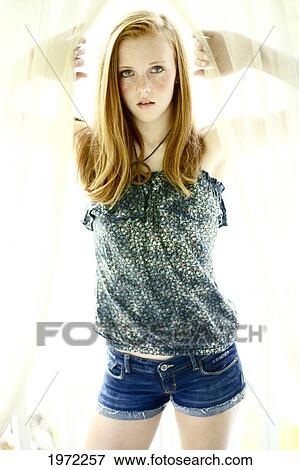 Attractive Young Woman Poses And Holds Curtain Open. View Large Photo Image Stock Photo - Attractive Young Woman Poses And Holds Curtain Open.. Fotosearch