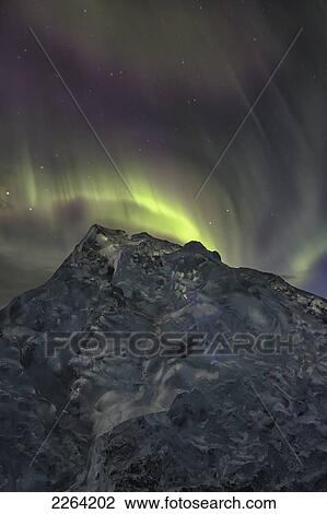 Stock Image - Aurora borealis dances over iceberg from the glacial lagoon jokulsarlon; iceland. Fotosearch