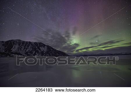 Stock Image - Aurora borealis dances over sheep mountain which is in kluane national park; yukon canada. Fotosearch