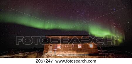 Stock Photo - Aurora Borealis Or Northern Lights Over Lodge, Manitoba.. Fotosearch