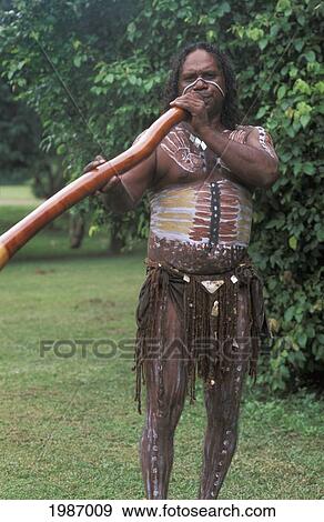 Stock Photo - Australia, Queensland, Aboriginal native man with paint on body playing Didgeridoo; Cairns. Fotosearch