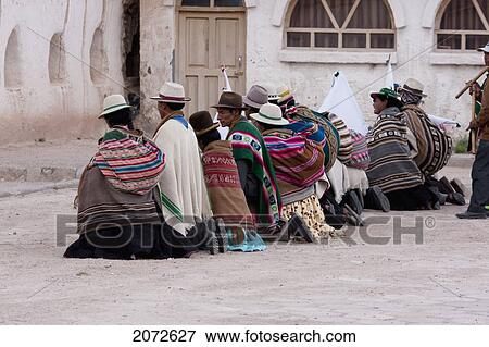 Stock Photo - Aymara Elders Kneeling In Front Of The Santiago De Curahuara De Carangas Church During Carnival, Curahuara De Carangas, Oruro, Bolivia. Fotosearch