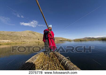 Stock Photo - Aymara man rowing a totora reed boat on Lake Titicaca, La Paz Department, Bolivia. Fotosearch