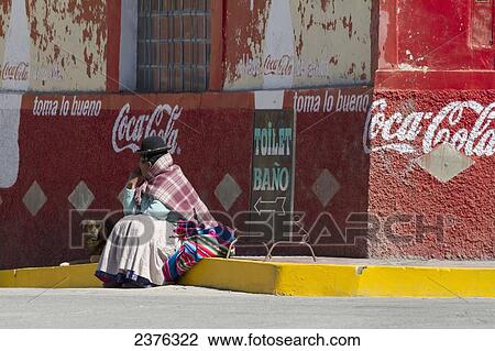 Stock Image - Aymara woman and dog by a store, Pomata, Puno, Peru. Fotosearch