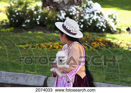Stock Image - Aymara Woman Carrying A Puppy, La Paz, Bolivia. Fotosearch