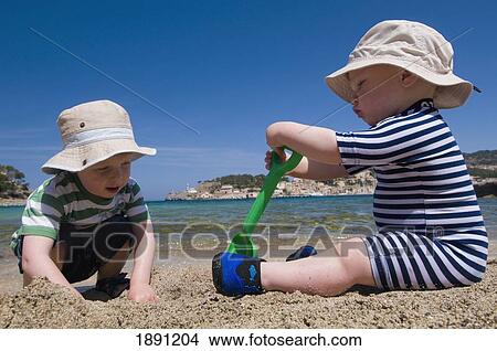 Baby Boy (6-11 Months) And Toddler (2-3) Playing In Sand On Beach View Large Photo Image Picture - Baby Boy (6-11 Months) And Toddler (2-3) Playing In Sand On Beach. Fotosearch