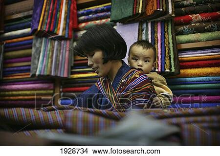 Picture - Baby On The Back Of A Woman Worker. Fotosearch