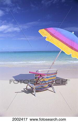 Stock Photo - Back View Of Beach Chair Under Umbrella, Snorkel Gear On Chair, Blue Sky Turquoise Ocean. Fotosearch
