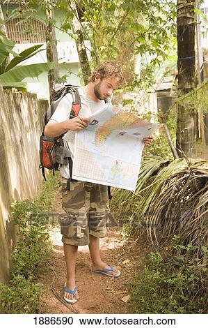 Stock Image - Backpacker On Path Looking At Map. Fotosearch
