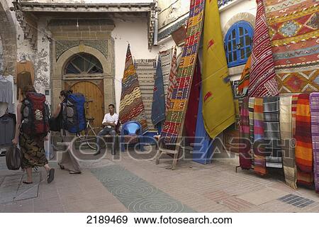 Stock Photo - Backpackers Wander Through Carpet Market In Essaouira, Morocco. Fotosearch