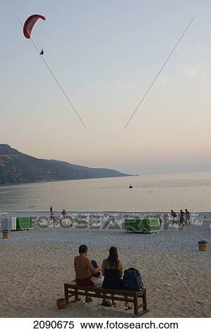 Backpackers Watching Paraglider Making The Final Sunset Descent Over Oludeniz At The Turquoise Coast, Southern Turkey View Large Photo Image Stock Photography - Backpackers Watching Paraglider Making The Final Sunset Descent Over Oludeniz At The Turquoise Coast, Southern Turkey. Fotosearch