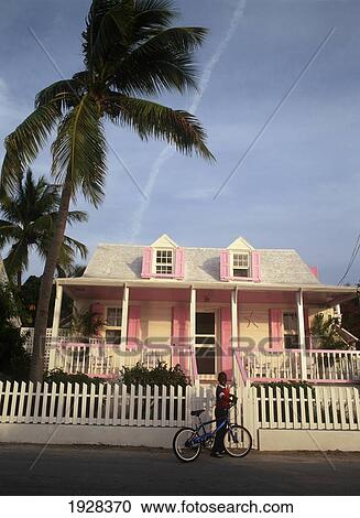 Stock Image - Bahamianboy And Pastel Painted House In Dunmore Town. Fotosearch