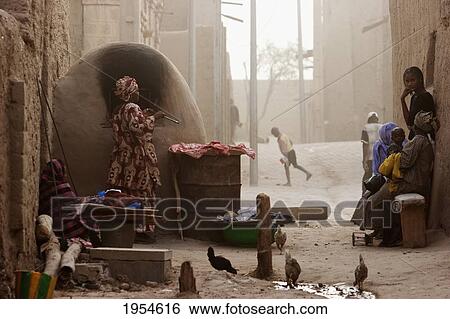 Stock Photograph - Baking bread in a mud oven, Timbuktu, Mali. Fotosearch