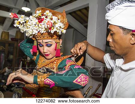 Balinese man assisting a dancer of the Raja Peni troupe with her costume before a dance performance, Ubud, Bali, Indonesia View Large Photo Image Stock Image - Balinese man assisting a dancer of the Raja Peni troupe with her costume before a dance performance, Ubud, Bali, Indonesia. Fotosearch