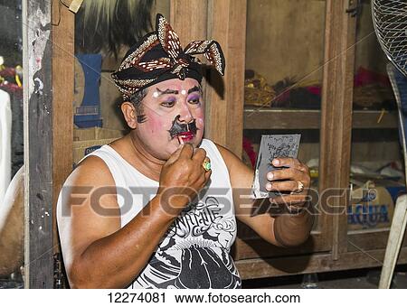 Balinese performer of the Raja Peni troupe applying make-up before a dance performance in front of a mirror, Ubud, Bali, Indonesia View Large Photo Image Stock Image - Balinese performer of the Raja Peni troupe applying make-up before a dance performance in front of a mirror, Ubud, Bali, Indonesia. Fotosearch