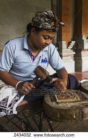 Stock Image - Balinese wood carver at the Museum Puri Lukisan, Ubud, Bali, Indonesia. Fotosearch