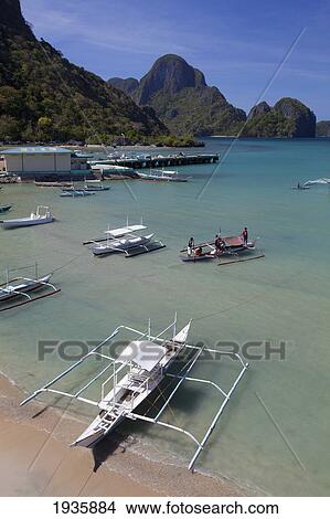 Picture - Bangka Boats Sit In The Picturesque And Scenic Bay; El Nido, Bacuit Archipelago, Palawan, Philippines. Fotosearch