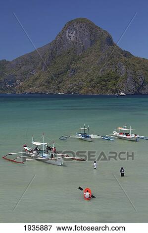 Stock Photo - Bangka Boats Sit In The Picturesque And Scenic Bay; El Nido, Bacuit Archipelago, Palawan, Philippines. Fotosearch