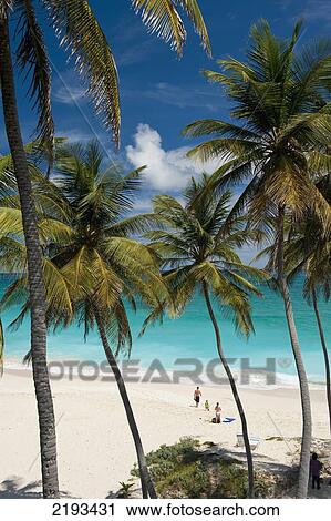 Stock Image - Barbados, Couple with child on beach; Bottom Bay. Fotosearch