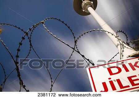 Stock Image - Barbed wire against blue sky in resort of Karaincir in the Bodrum Peninsula; Turkey. Fotosearch