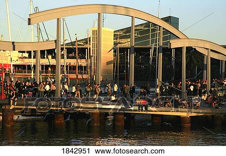 Stock Image - Barcelona, Spain; People Strolling Along The Harbour Front. Fotosearch