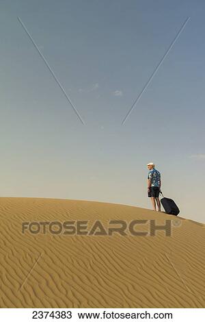 Barefoot man with suitcase on sand dune; Dubai, United Arab Emirates View Large Photo Image Stock Image - Barefoot man with suitcase on sand dune; Dubai, United Arab Emirates. Fotosearch