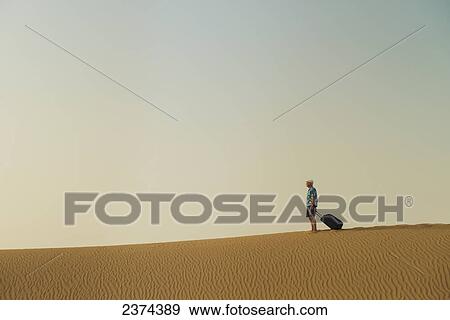 Barefoot man with suitcase on sand dune; Dubai, United Arab Emirates View Large Photo Image Stock Photo - Barefoot man with suitcase on sand dune; Dubai, United Arab Emirates. Fotosearch