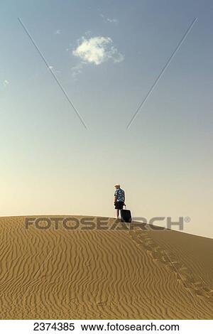 Barefoot man with suitcase on sand dune; Dubai, United Arab Emirates View Large Photo Image Stock Photography - Barefoot man with suitcase on sand dune; Dubai, United Arab Emirates. Fotosearch