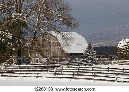 Stock Photo - Barn roof and farmyard covered with snow in winter; Bromont, Quebec, Canada. Fotosearch