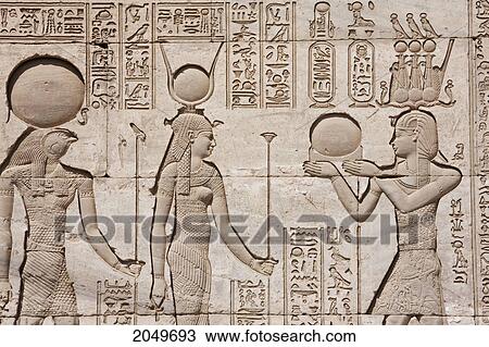 Stock Image - Bas-Relief Of The Gods Horus And Hathor Receiving An Offering From Trajan On The External Wall Of The Roman Mammisi (Birth House), Dendera, Qina, Egypt. Fotosearch