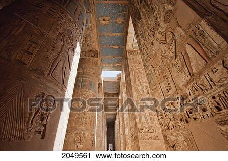 Stock Image - Bas-Reliefs With Original Colors On The Walls And Columns Of A Portico Of The Second Courtyard Of The Mortuary Temple Of Ramses Iii, Medinat Habu, Luxor, Qina, Egypt. Fotosearch