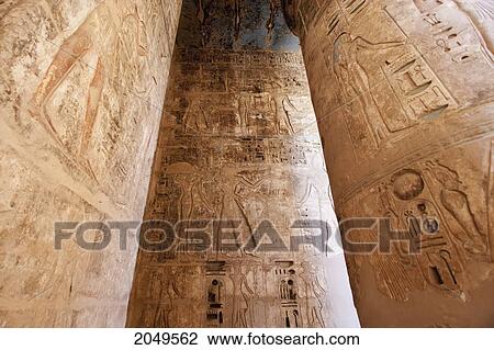 Stock Image - Bas-Reliefs With Original Colors On The Walls And A Column Of A Portico Of The Second Courtyard Of The Mortuary Temple Of Ramses Iii, Medinat Habu, Luxor, Qina, Egypt. Fotosearch