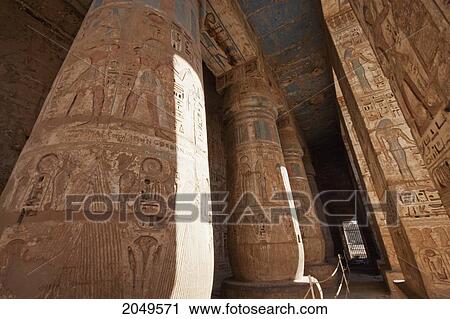 Stock Image - Bas-Reliefs With Original Colors On The Walls And Columns Of A Portico Of The Second Courtyard Of The Mortuary Temple Of Ramses Iii, Medinat Habu, Luxor, Qina, Egypt. Fotosearch