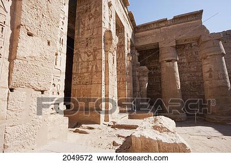 Stock Image - Bas-Reliefs With Original Colors On The Walls Of A Portico Of The Second Courtyard Of The Mortuary Temple Of Ramses Iii, Medinat Habu, Luxor, Qina, Egypt. Fotosearch