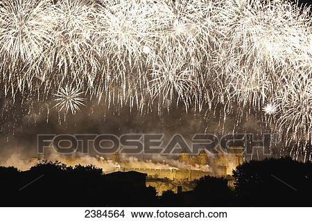 Picture - Bastille Day fireworks display with castle and ramparts illuminated at nighttime; Carcassonne, Languedoc-Rousillion, France. Fotosearch