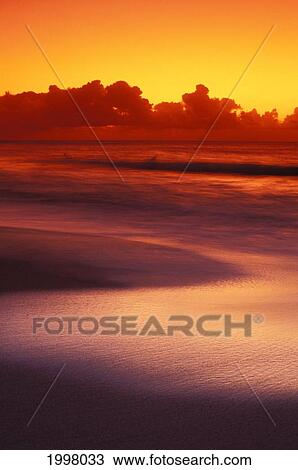 Beach At Sunset With Gentle Wave Rolling In, Dark Orange Sky With Silver Reflections On Water View Large Photo Image Stock Image - Beach At Sunset With Gentle Wave Rolling In, Dark Orange Sky With Silver Reflections On Water. Fotosearch
