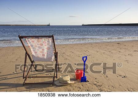 Stock Photo - Beach Chair And Personal Items On Beach. Fotosearch