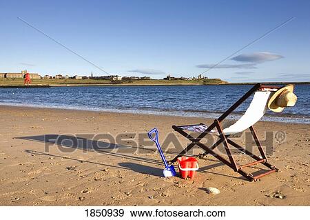 Stock Photo - Beach Chair And Personal Items On Beach. Fotosearch