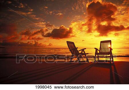 Stock Photography - Beach Chairs Along Shoreline At Twilight, Amazing Sunset. Fotosearch