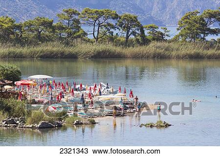 Stock Image - Beach with umbrellas and lounge chairs; Oludeniz, Mugla Province, Turkey. Fotosearch