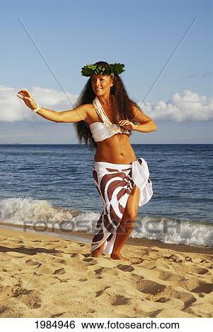 Stock Photograph - Beautiful Hawaiian girl dancing hula on ocean shoreline. Fotosearch