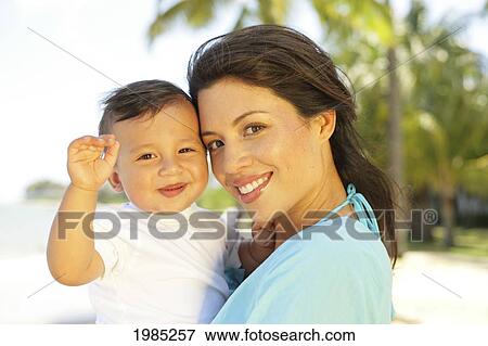 Beautiful Local Mother Holding Little Boy, Palm Tree In Background. View Large Photo Image Stock Photo - Beautiful Local Mother Holding Little Boy, Palm Tree In Background.. Fotosearch
