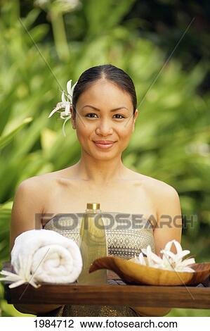 Stock Image - Beautiful Polynesian Woman At A Spa Holding A Tray Of Spa Implements.. Fotosearch