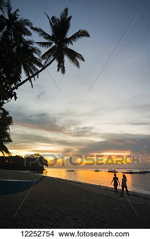 Beautiful sunrise in Alona Beach, friends walking on the sand; Panglao Island, Bohol, Philippines View Large Photo Image Picture - Beautiful sunrise in Alona Beach, friends walking on the sand; Panglao Island, Bohol, Philippines. Fotosearch