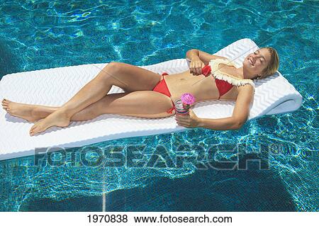 Stock Photo - Beautiful Teenager On A Raft In A Swimming Pool. Fotosearch