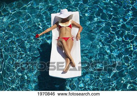Stock Photograph - Beautiful Teenager On A Raft In A Swimming Pool. Fotosearch