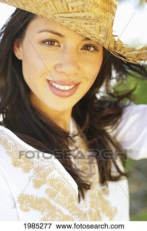 Stock Photo - Beautiful Young Woman Wearing A Straw Hat.. Fotosearch